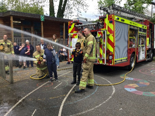 Fire fighters demonstrating to pupils
