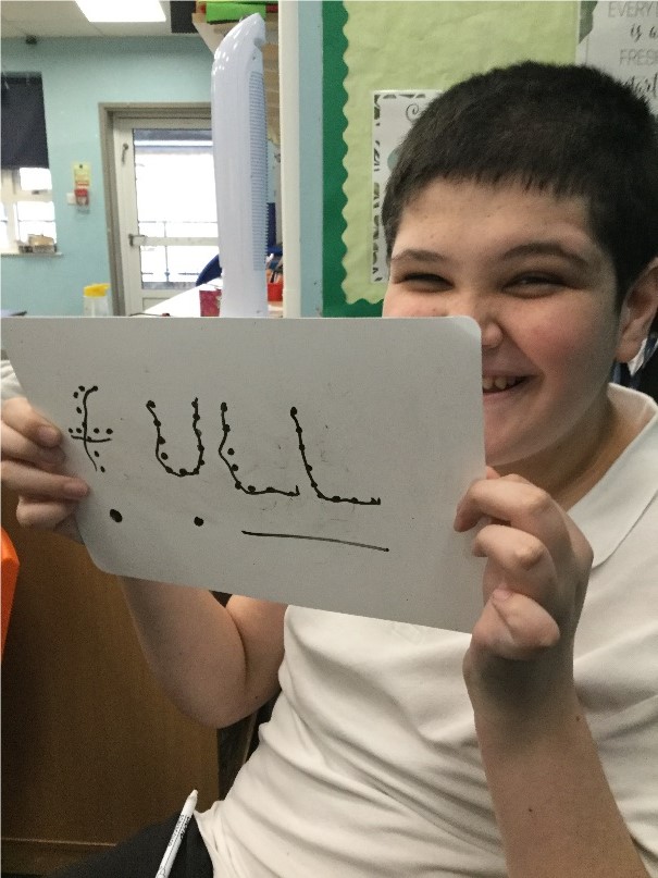Pupil holding up the word full